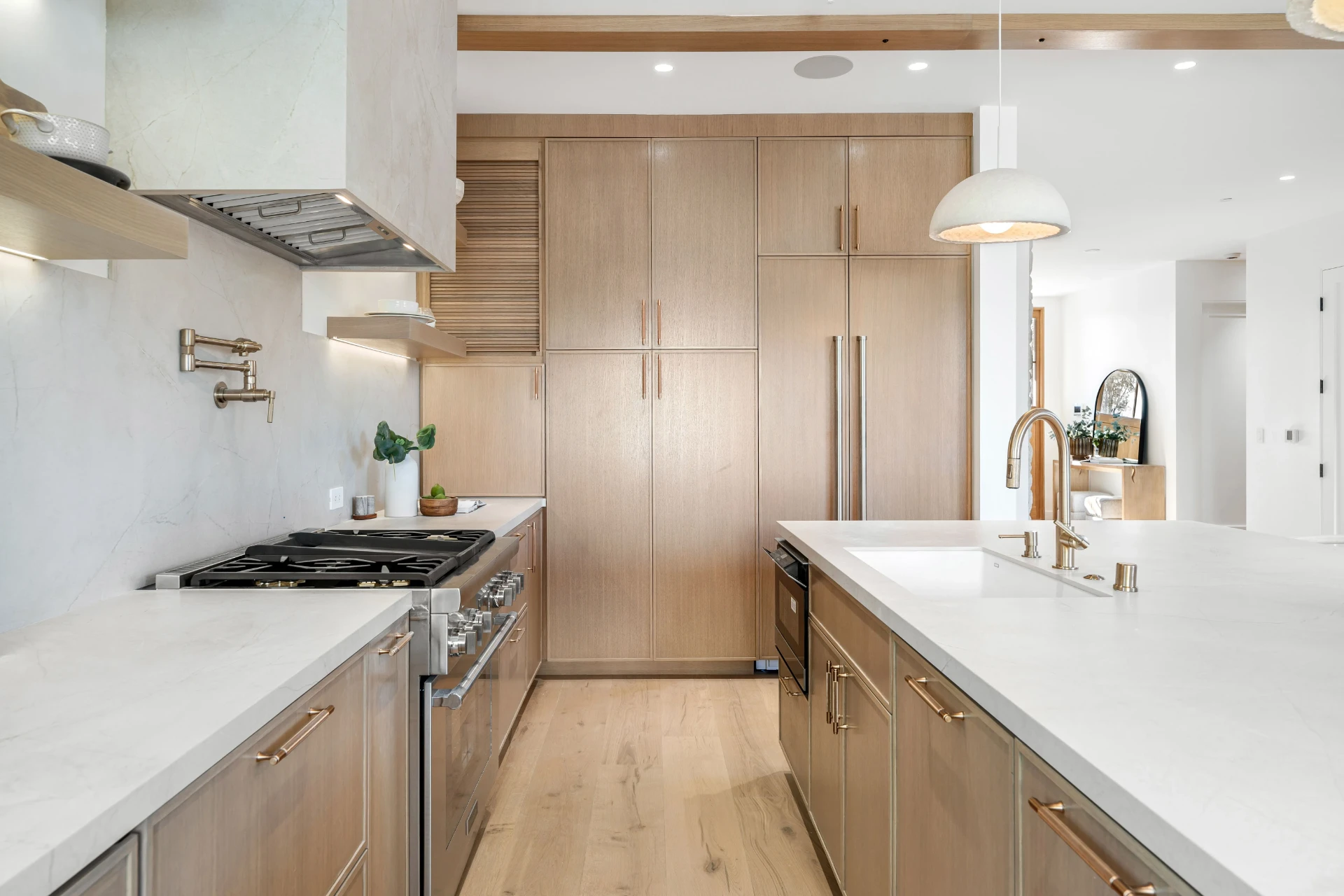 Ljust kök med marmorbänkskiva och köksö efter renovering i Stockholm